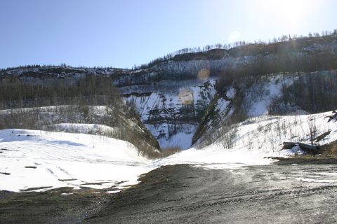 2003 Jeep TJ - A wide view of a snow-covered canyon with rocky cliffs and sparse trees under a clear blue sky.