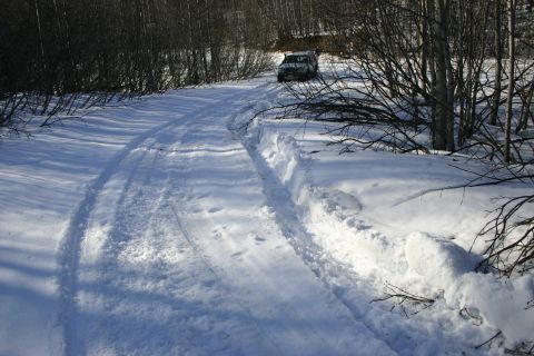 2003 Jeep TJ - SUV navigates a snowy path through a wooded area.