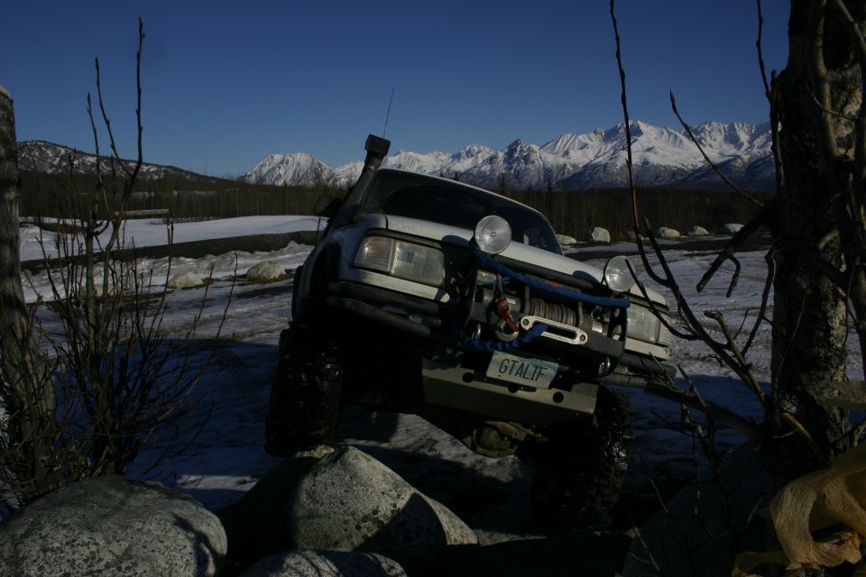 White off-road vehicle with winch and snorkel on rocky terrain