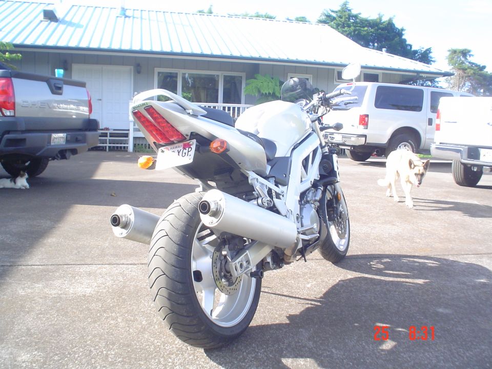 Silver Suzuki naked sportbike from rear with dual exhausts, Hawaii plate, in driveway