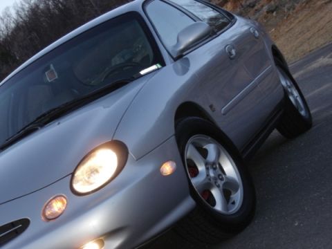 1999 Ford Taurus - Front quarter view of a silver 1999 Ford Taurus sedan on a road.