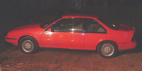 1991 Chevrolet Beretta - Side view of a red 1991 Chevrolet Beretta coupe.