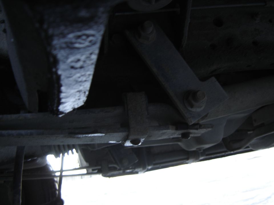 Undercarriage of a vehicle with visible suspension components and a Supermotors.net watermark