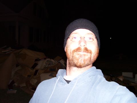 1992 Ford Bronco - Man in beanie and hoodie poses for a photo at night with a pile of boxes in the background.