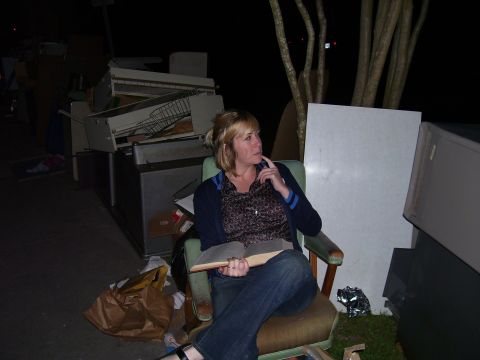 1992 Ford Bronco - A woman sits in a chair amidst a pile of discarded furniture and trash.