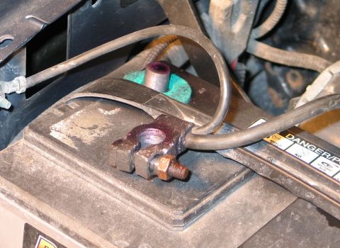 1994 Ford Bronco - A close-up view of a vehicle's battery terminal and attached cable, showing signs of corrosion.