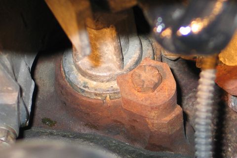 1994 Ford Bronco - This image shows a heavily rusted bolt and bracket assembly, likely from the underside of a vehicle.