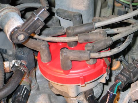 1994 Ford Bronco - Close-up of a vehicle's ignition system, showing a distributor cap and spark plug wires.