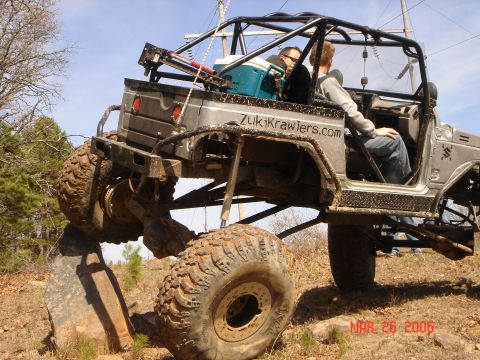 1978 Ford Bronco - Suzuki Samurai modified for off-road use, navigating a rocky obstacle. ZukiKrawlers.com is displayed on the vehicle's body.