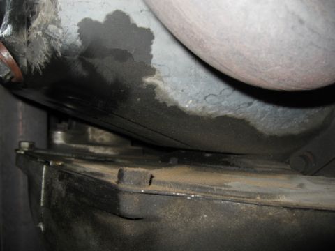 2000 Jeep TJ - Underside view of a vehicle's mechanical components, revealing significant oil leakage.