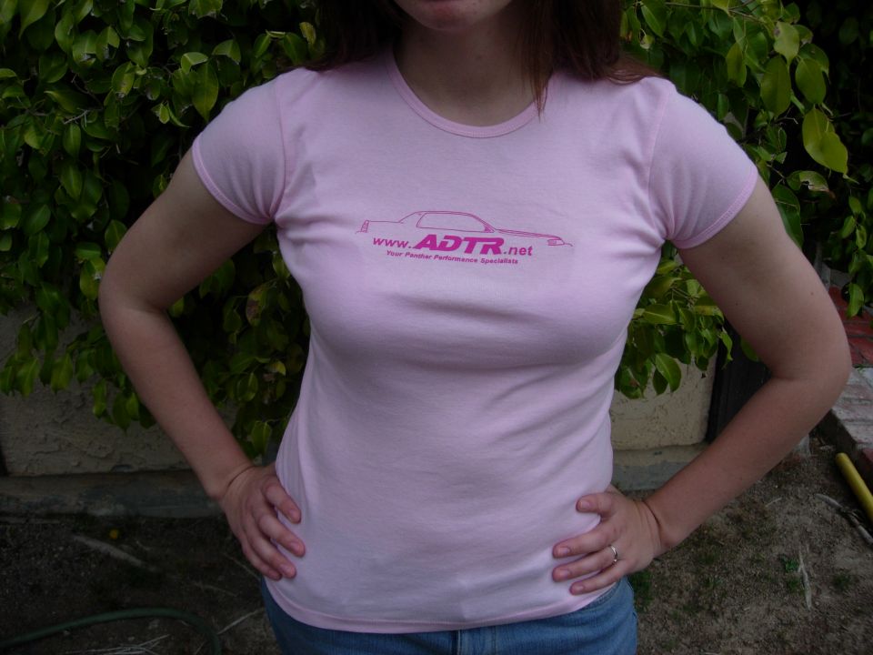 Person in pink T-shirt with ADTR.net car-silhouette logo outdoors