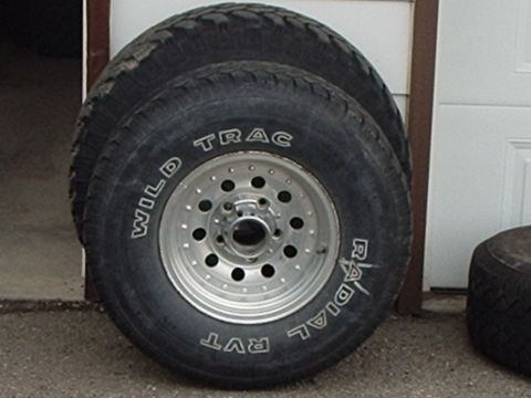 1990 Ford Bronco - Two Wild Trac Radial RVT tires are shown mounted on aluminum rims, likely for sale or storage.