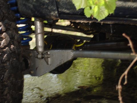 1989 Ford Bronco - The underside of an off-road vehicle shows its suspension components, including a shock and coil spring.