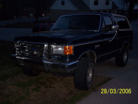 1991 Ford Bronco - This 1991 Ford Bronco is parked in a driveway at night, showing its front three-quarter view.