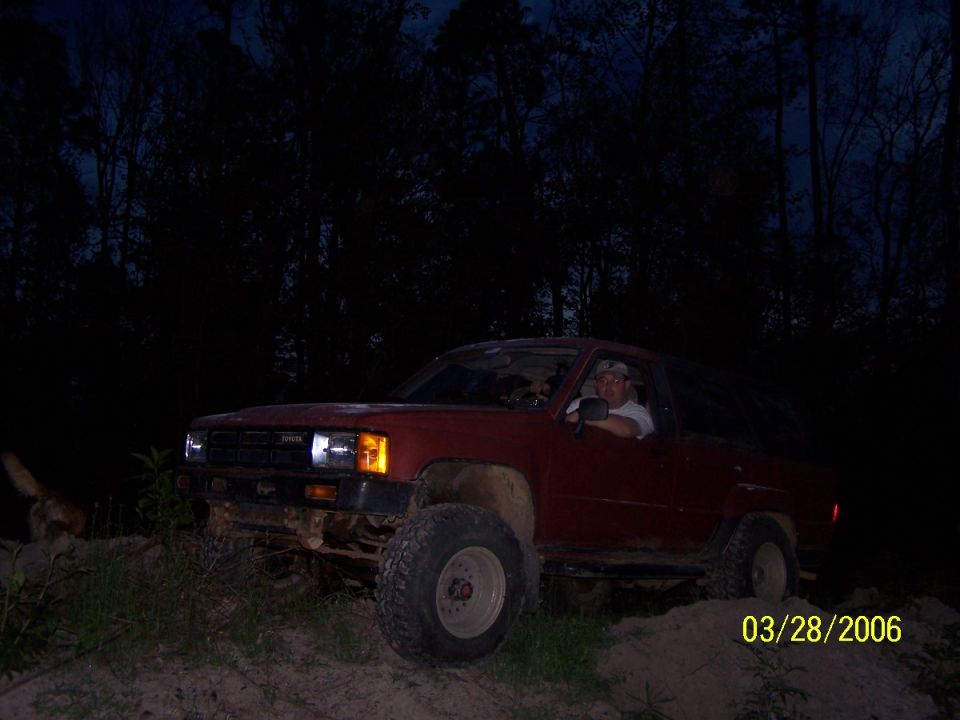 Red 1984 Toyota 4Runner parked off-road at night with a driver inside