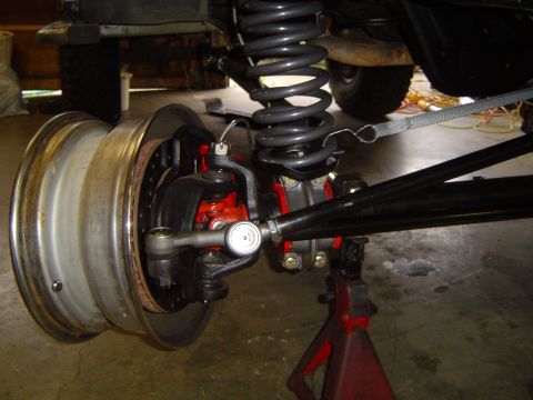 1989 Ford Bronco - Close-up view of a vehicle's front axle and suspension system, with a wheel and brake assembly visible.