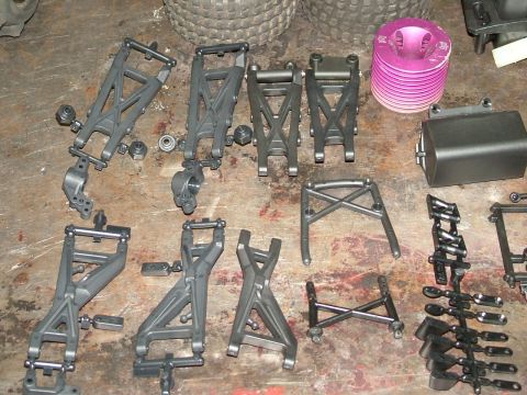 1994 Ford Bronco - Various unassembled parts for an RC car, including suspension components and a glow engine.