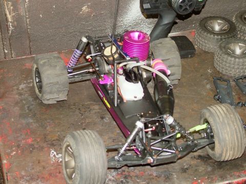 1994 Ford Bronco - A radio-controlled nitro buggy sits on a workbench with spare parts and a remote.
