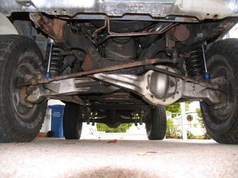 1984 Ford Bronco - The underside of a vehicle, showing its mechanical components and suspension system.