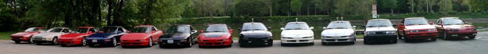 Panoramic row of about a dozen 1990s sport coupes and sedans lined up at a park car meet