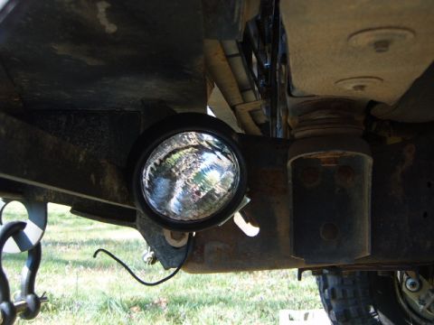1988 Ford Bronco - A rock light is mounted to the frame of a vehicle, alongside a heavy-duty shackle.