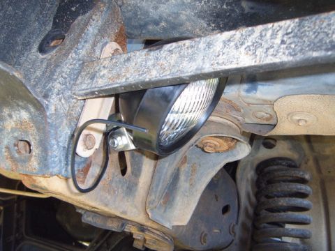 1988 Ford Bronco - Aftermarket rock light installed on the underside of a vehicle frame.