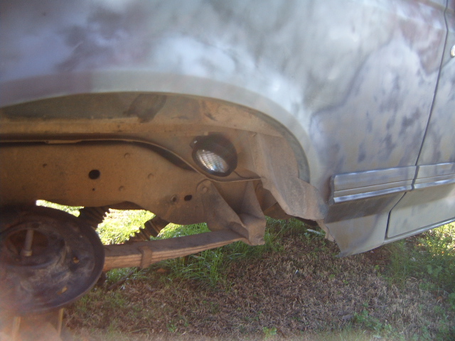 Rock light installed on vehicle frame near rear wheel well