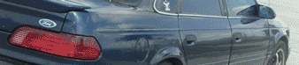1993 Ford Taurus - The rear of a 1993 Ford Taurus sedan, showing its distinctive taillight and spoiler.