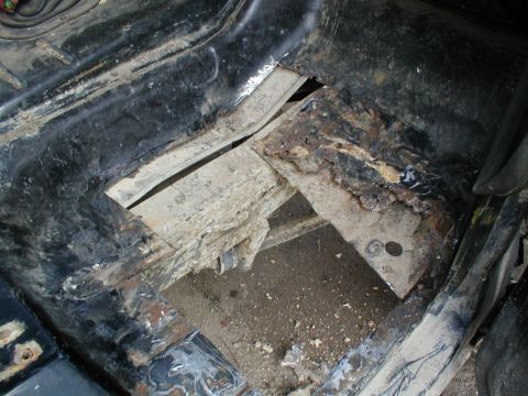1979 Ford Bronco - The interior floor pan shows significant rust and damage, indicating poor condition.