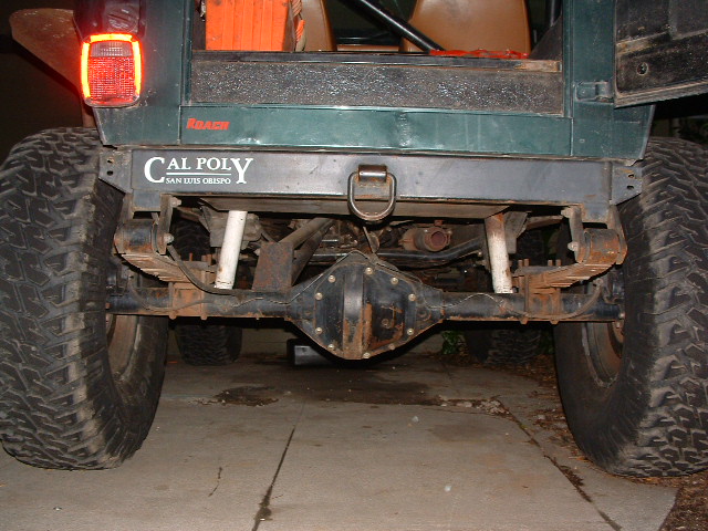Rear view of a Jeep showing its axle, leaf springs, and large tires. Has a 'Cal Poly San Luis Obispo' sticker