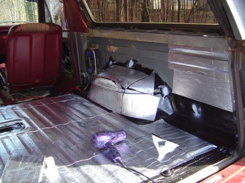 1978 Ford Bronco - Sound deadening material is being applied to the interior floor and rear panels of a vehicle.