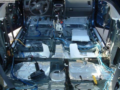 1978 Ford Bronco - The interior of a car is shown with sound deadening material and wiring exposed, indicating a sound system installation or modification.