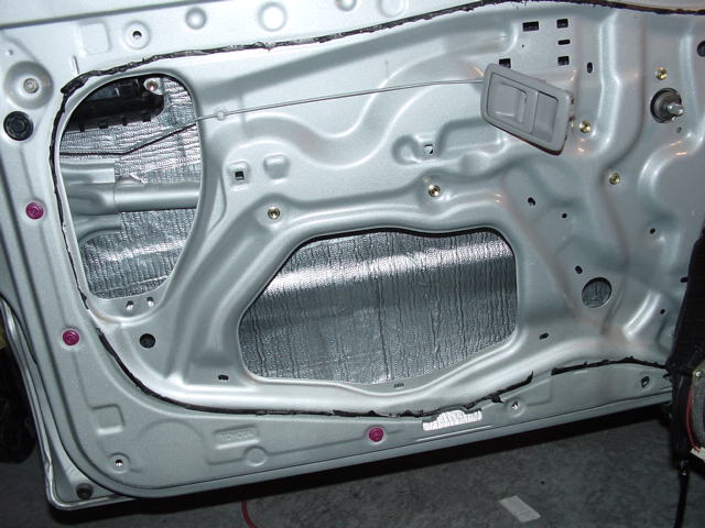 Interior door panel with silver sound deadening material applied