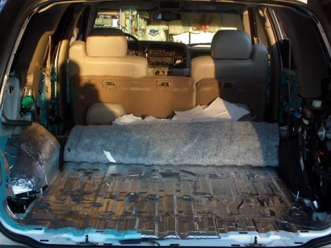 1978 Ford Bronco - The interior cargo area of a vehicle is being prepared for sound deadening installation.