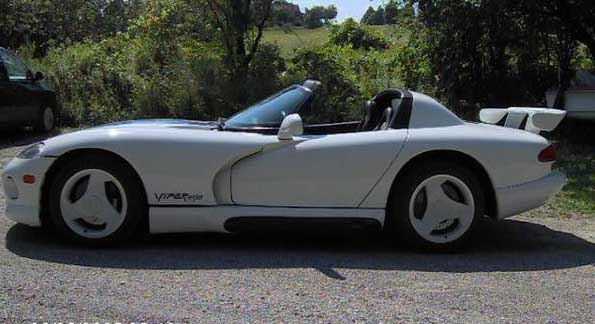 White convertible sports car with a rear spoiler and Viper badging, seen from the side
