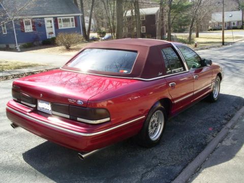 1995 Ford Crown Victoria - This 1995 Ford Crown Victoria sedan is shown from its rear quarter, highlighting its red paint and maroon vinyl top.