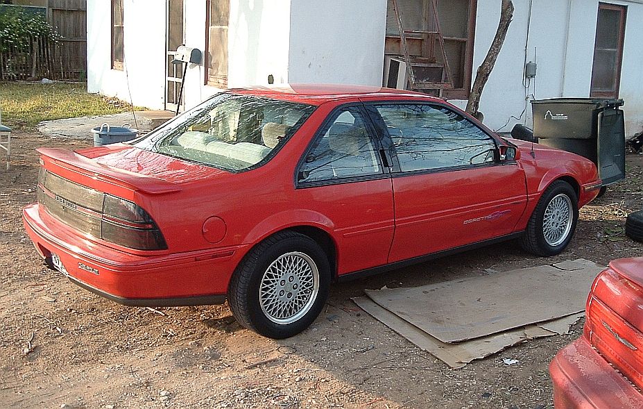 Red Chevrolet Beretta GT coupe with rear spoiler, rear three-quarter view