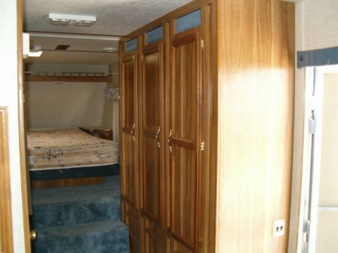 1985 Ford Bronco - Interior view of an RV, a bed and storage cabinets.