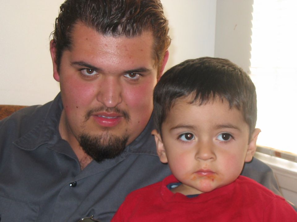 Man and child posing for photo with Supermotors.net logo