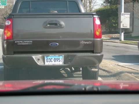 1992 Ford Taurus - The rear of a gray Ford Explorer Sport Trac Adrenalin pickup truck is visible, its tailgate and license plate.