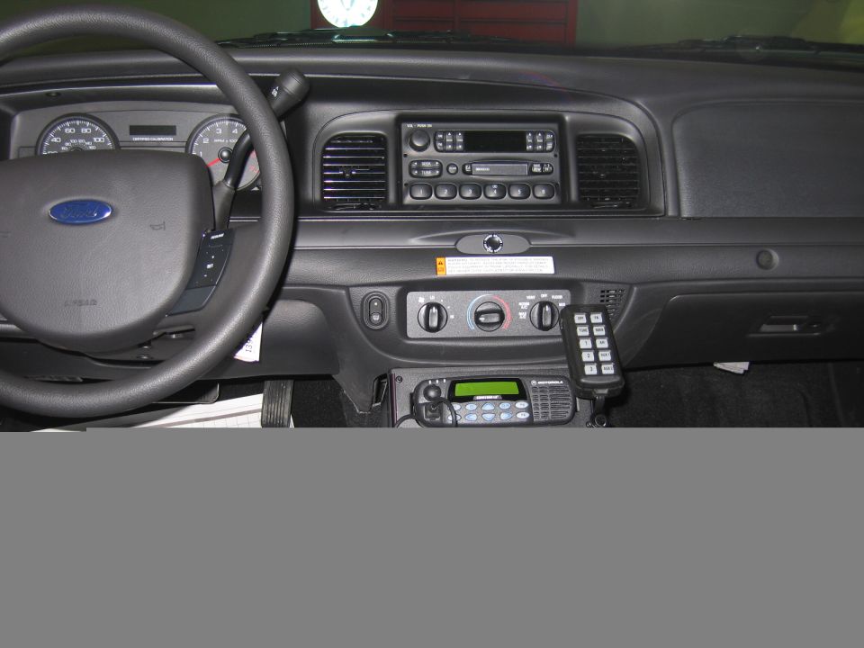 Ford police car dashboard with steering wheel, radio and mounted keypad