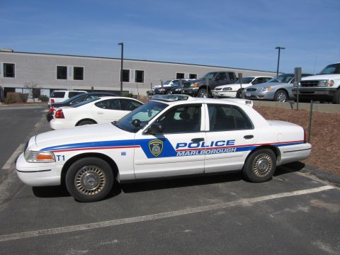 1991 Ford LTD Crown Victoria - white Ford Crown Victoria police car lettered POLICE MARLBOROUGH is parked in a lot under a clear blue sky.