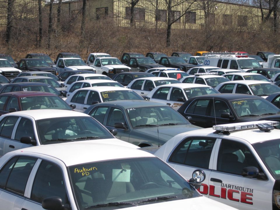 Crowded lot of police vehicles with a Dartmouth Police cruiser and Auburn PD car
