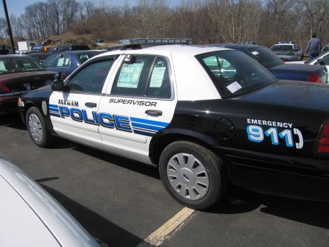1991 Ford LTD Crown Victoria - black-and-white Agawam Police Supervisor Ford sedan with blue striping and 'EMERGENCY 911' on the rear quarter, parked in a lot.