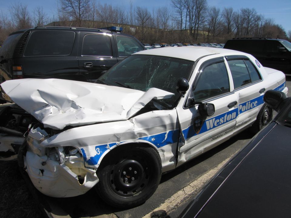 Heavily front-crashed white and blue Weston Police Ford sedan