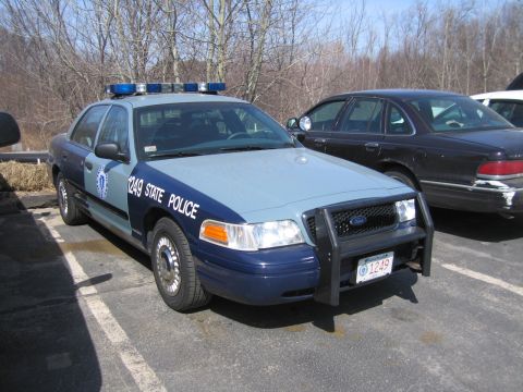 1991 Ford LTD Crown Victoria - two-tone blue Ford State Police sedan numbered 1249 with light bar and push bar, parked beside a maroon sedan.