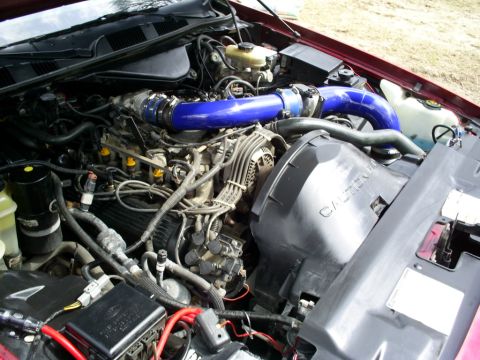 1995 Ford Crown Victoria - The engine bay of a vehicle, showing various components and blue intake piping.