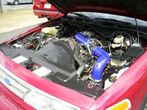 1995 Ford Crown Victoria - Engine bay of a 1995 Ford Crown Victoria showing the V8 engine with custom blue intake piping.