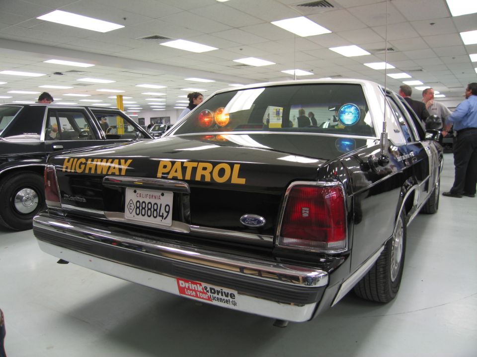 Rear of black Ford Highway Patrol sedan with gold lettering, California plate 888849