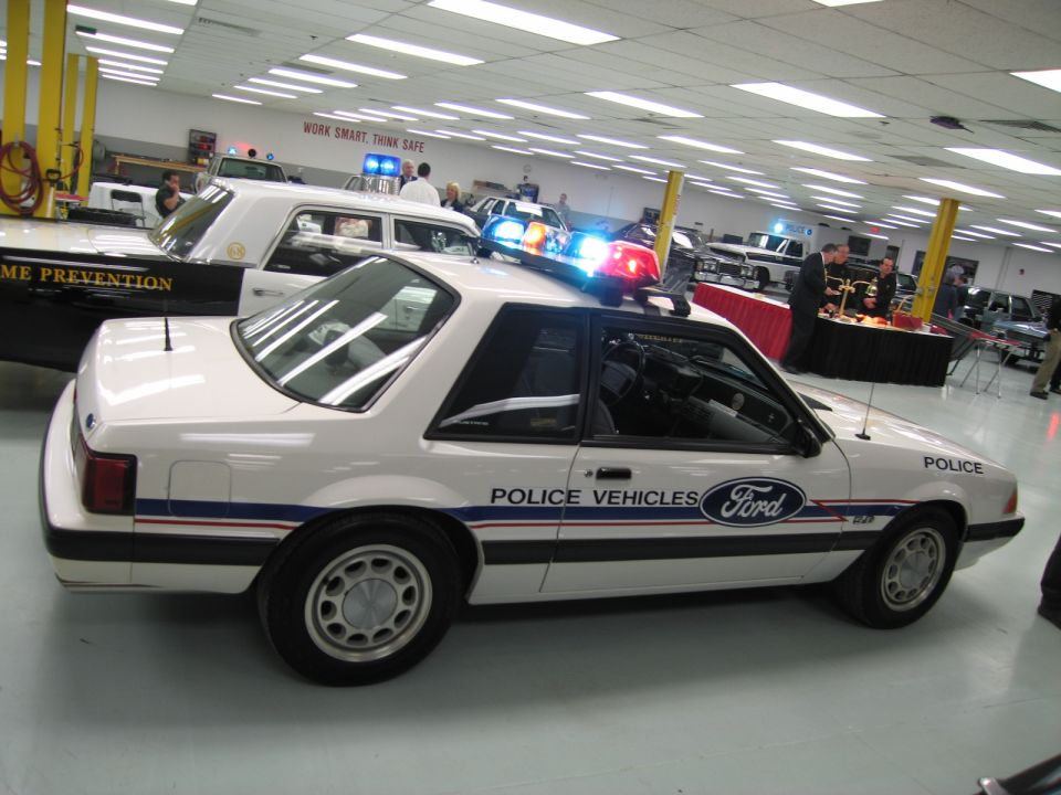 White Ford Mustang police car with blue lightbar, Police Vehicles graphics, indoors